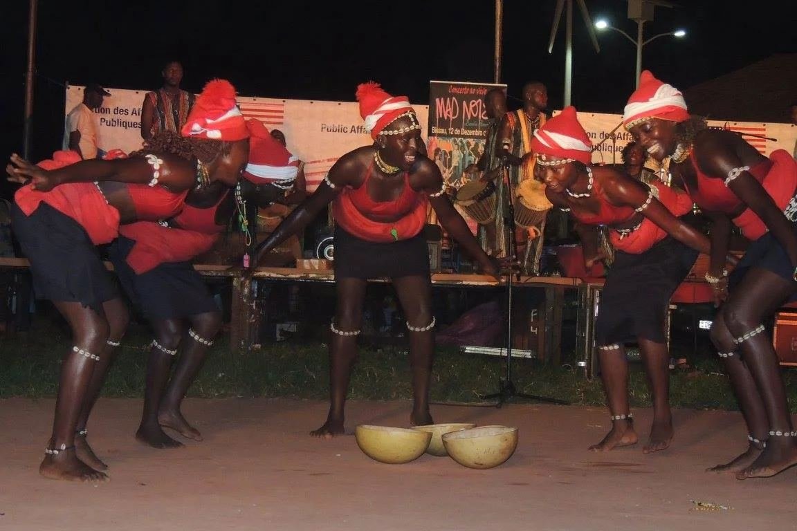 Bailarinas de vermelho a dançar ao ar livre à noite